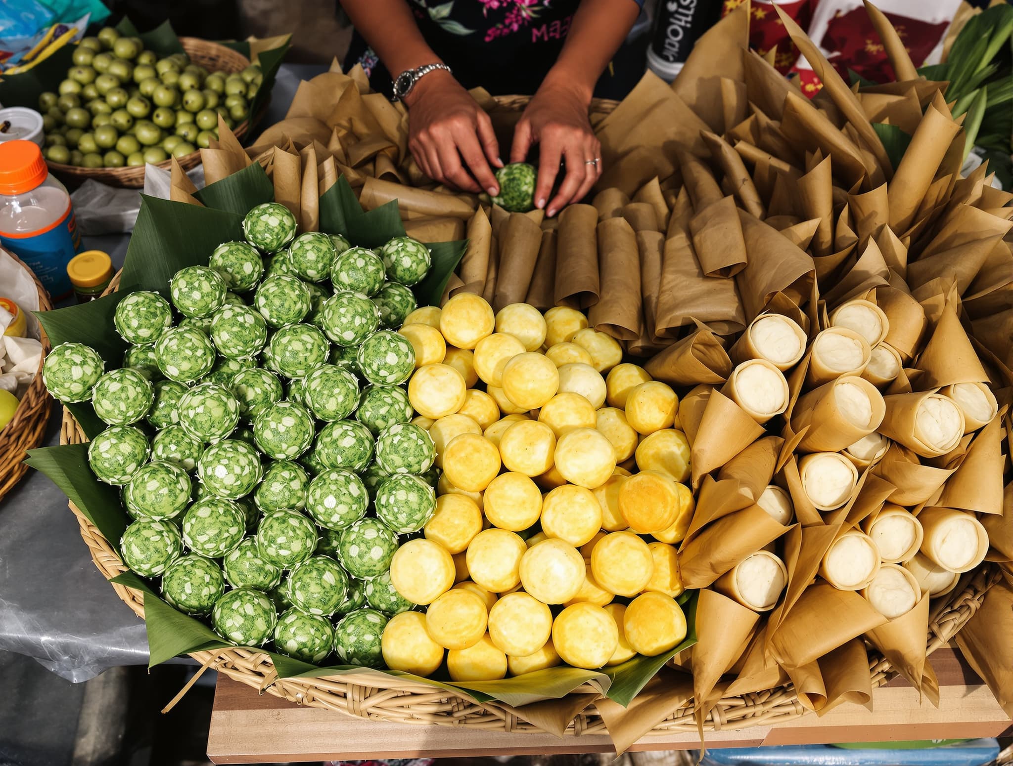 Balinese jajan sweets at a morning market — klepon, dadar gulung, and banana-leaf-wrapped rice cakes arranged on a vendor's table, representing the market snack culture described in the must-try dishes section.