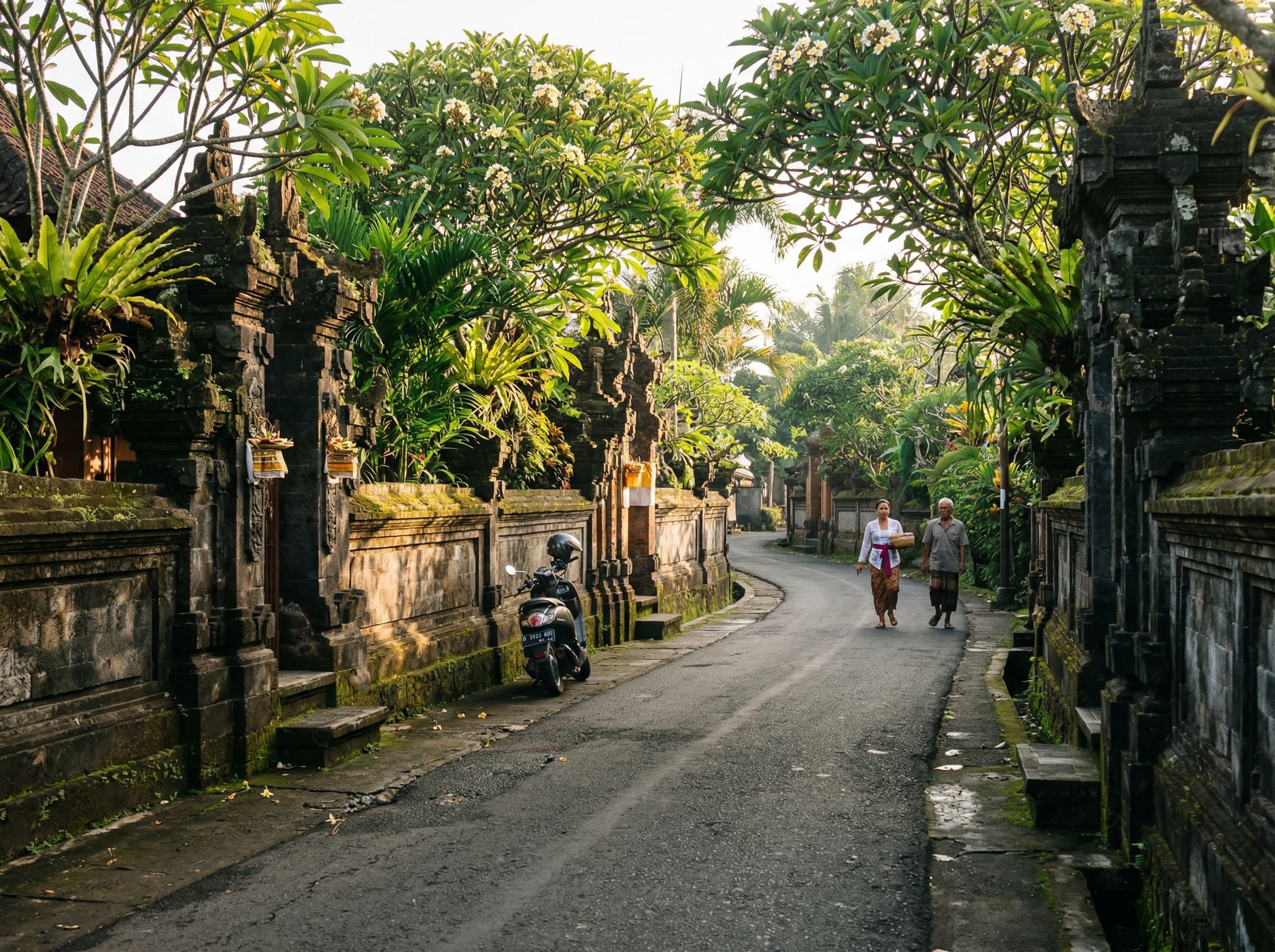 The Pengosekan neighborhood surrounding ARMA — the historic artists' community south of central Ubud, showing the narrow road lined with stone walls, frangipani trees, and painters' studios that gives this part of Ubud its quieter, more authentic character compared to the tourist-dense center.
