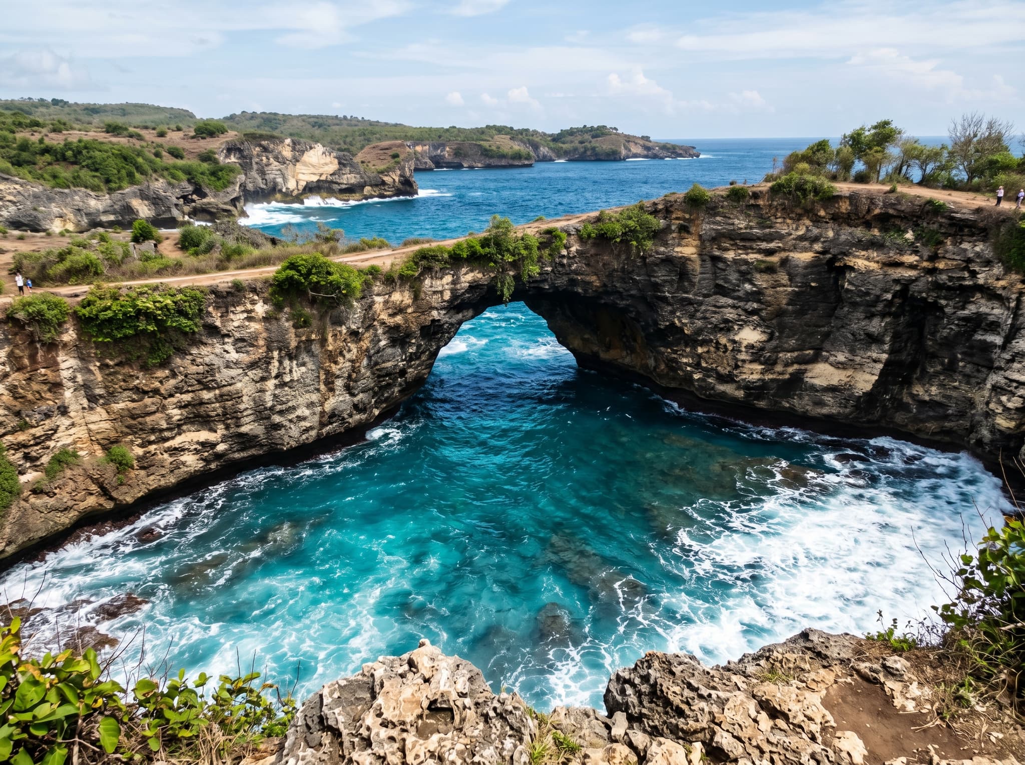 Close view of the natural limestone rock arch at Broken Beach spanning the channel between the cove and the open Indian Ocean, showing the geological structure described in the article's formation section
