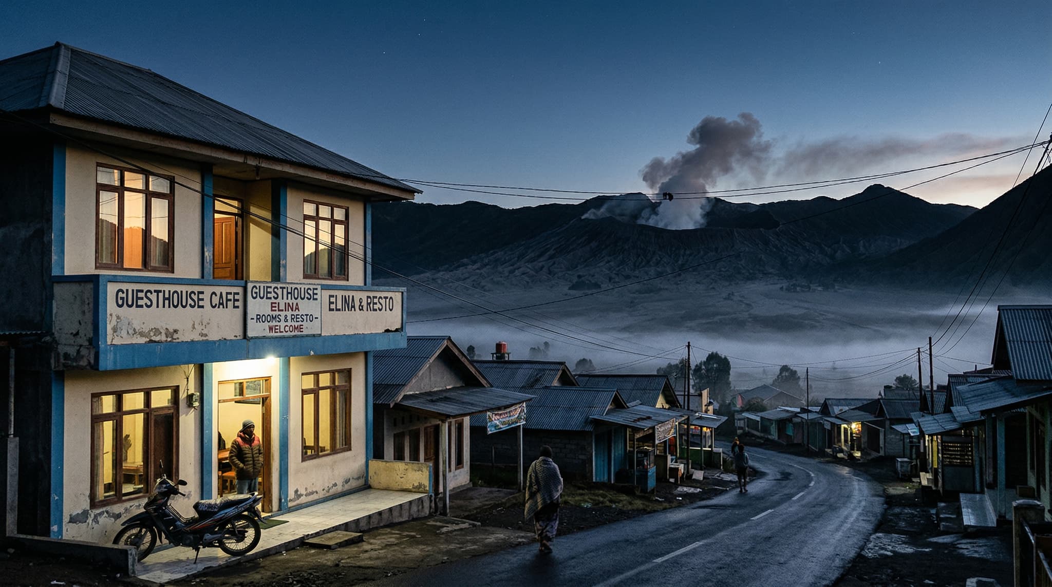 Cafe Lava Hostel exterior in Cemoro Lawang village at dawn, with Mount Bromo's volcanic crater and smoke plume visible in the background — establishing the hostel's extraordinary proximity to the caldera that makes it the go-to budget base for Bromo sunrise trips
