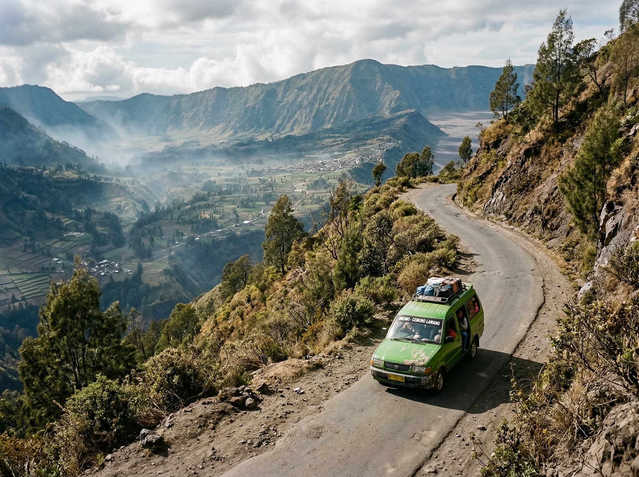 Winding mountain road from Probolinggo up to Cemoro Lawang village through the Tengger highlands — the final leg of the journey to Cafe Lava Hostel, traveled by local minivan on steep switchbacks through volcanic highland terrain