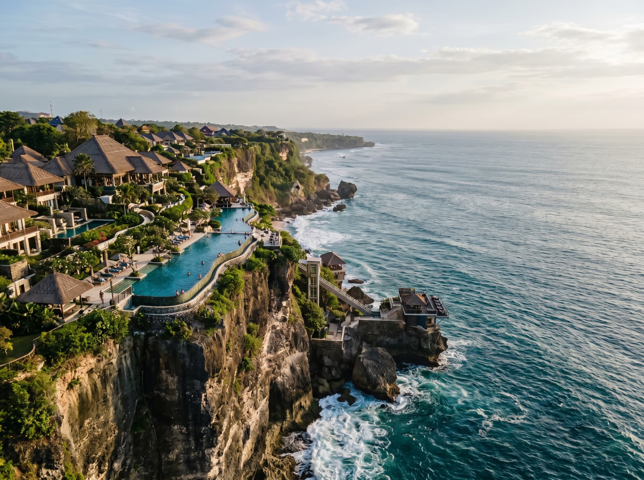 The limestone cliffs of the Ayana estate rising above the Indian Ocean south of Jimbaran Bay, showing the dramatic elevation that defines the luxury cliff-resort experience — and explains why beach access requires an inclinator