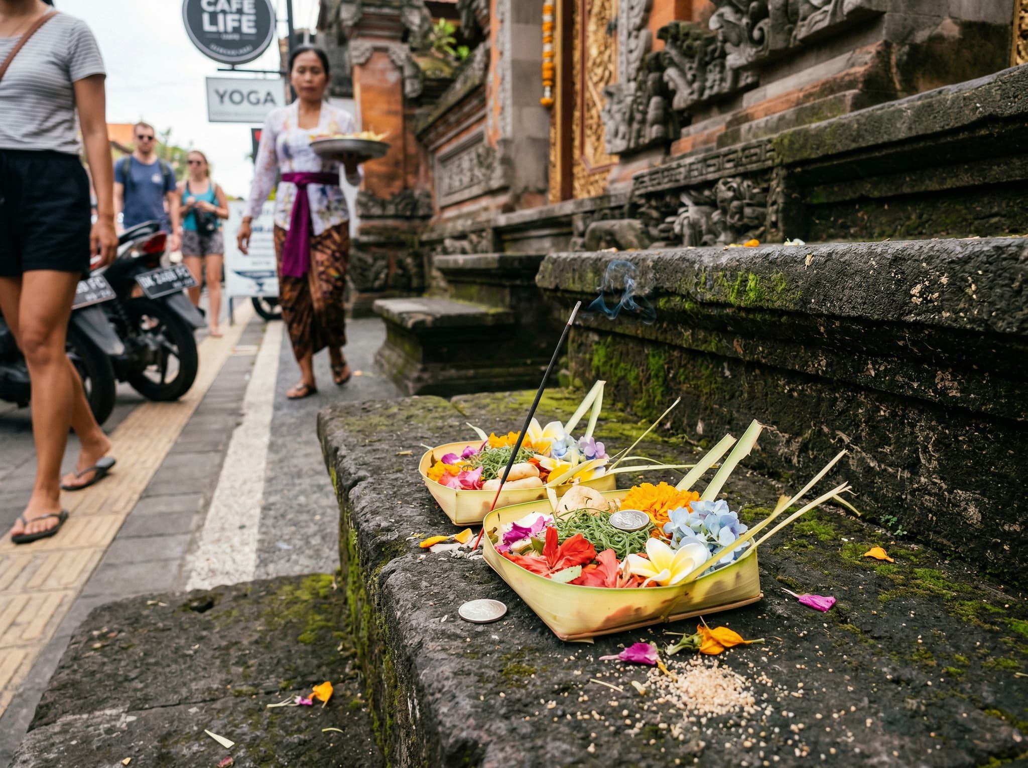 Canang sari offerings — small woven palm-leaf baskets with flowers and incense placed on a Canggu sidewalk or temple step — illustrating the article's cultural respect section and the Hindu-Balinese community that exists beneath Canggu's international surface