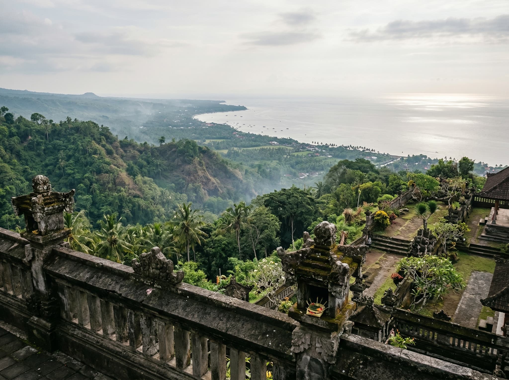 View from the upper terraces of Brahmavihara-Arama looking toward the Lovina coast and the Java Sea — illustrating the article's tip about arriving early for panoramic views, and grounding the monastery's hillside position above the northern coast