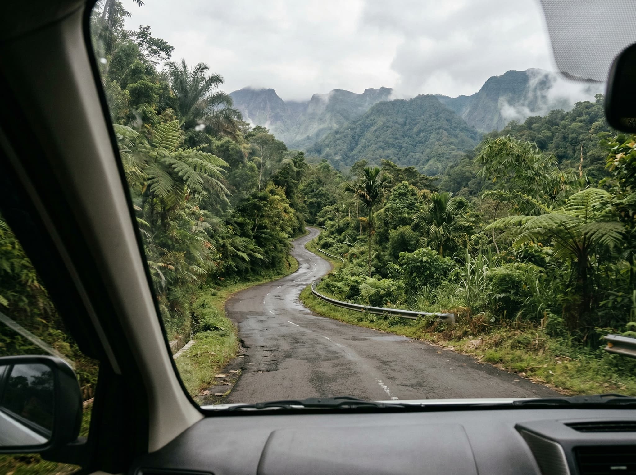 A narrow mountain road winding through East Lombok's interior highlands toward Sembalun Village — conveying the 3-to-4-hour drive from Mataram that the article describes, with the road narrowing and climbing as it moves inland.