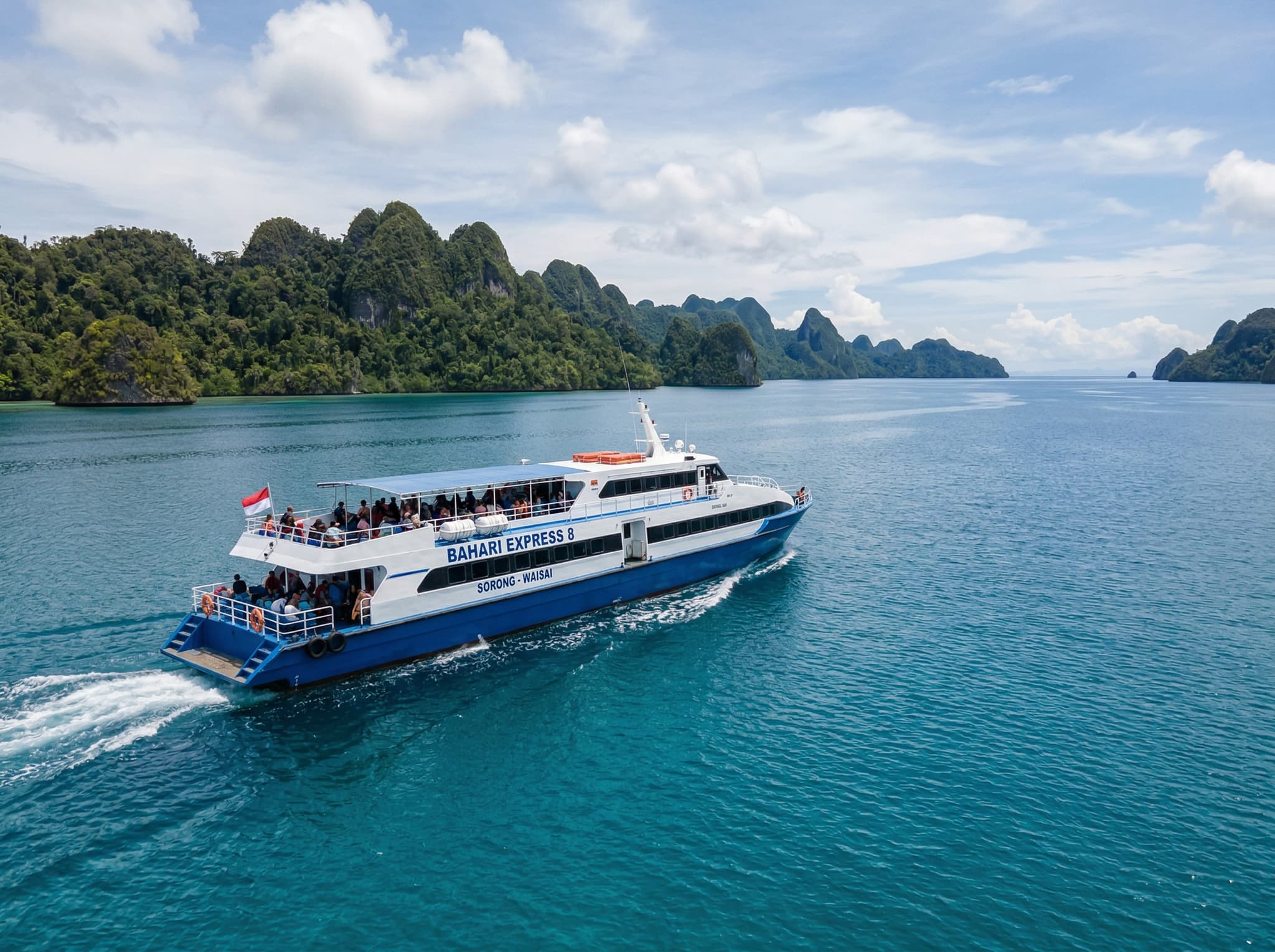 The Bahari Express passenger ferry crossing calm tropical waters between Sorong and Waisai, representing the two-hour sea crossing that begins every traveler's journey into Raja Ampat — grounding the article's practical getting-there section with a real sense of the route