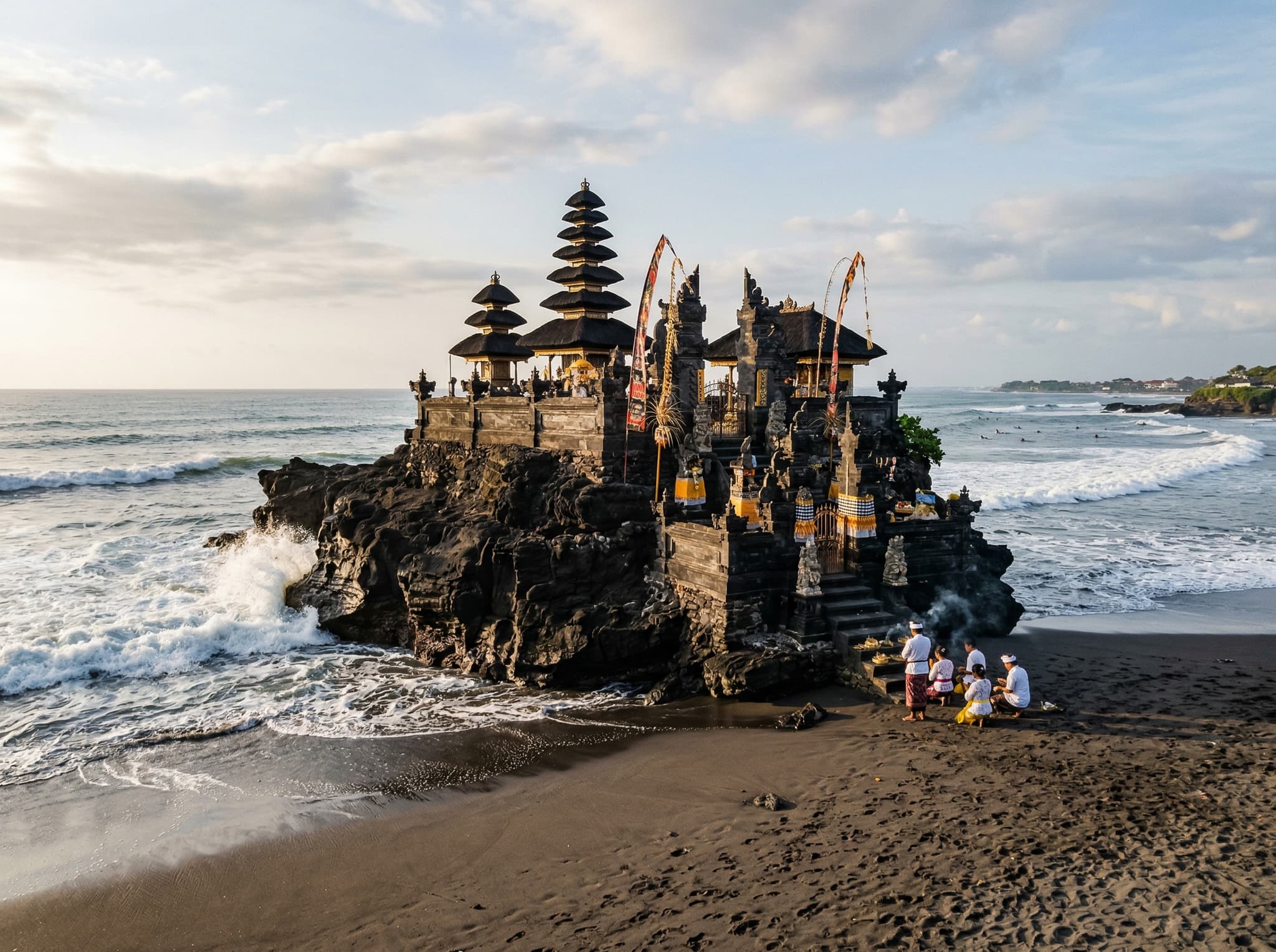 Pura Batu Bolong sea temple perched on its dark volcanic rock outcrop at the northern end of Batu Bolong Beach, Canggu — the landmark that gives the beach its name and its most recognizable silhouette against the Bali sky