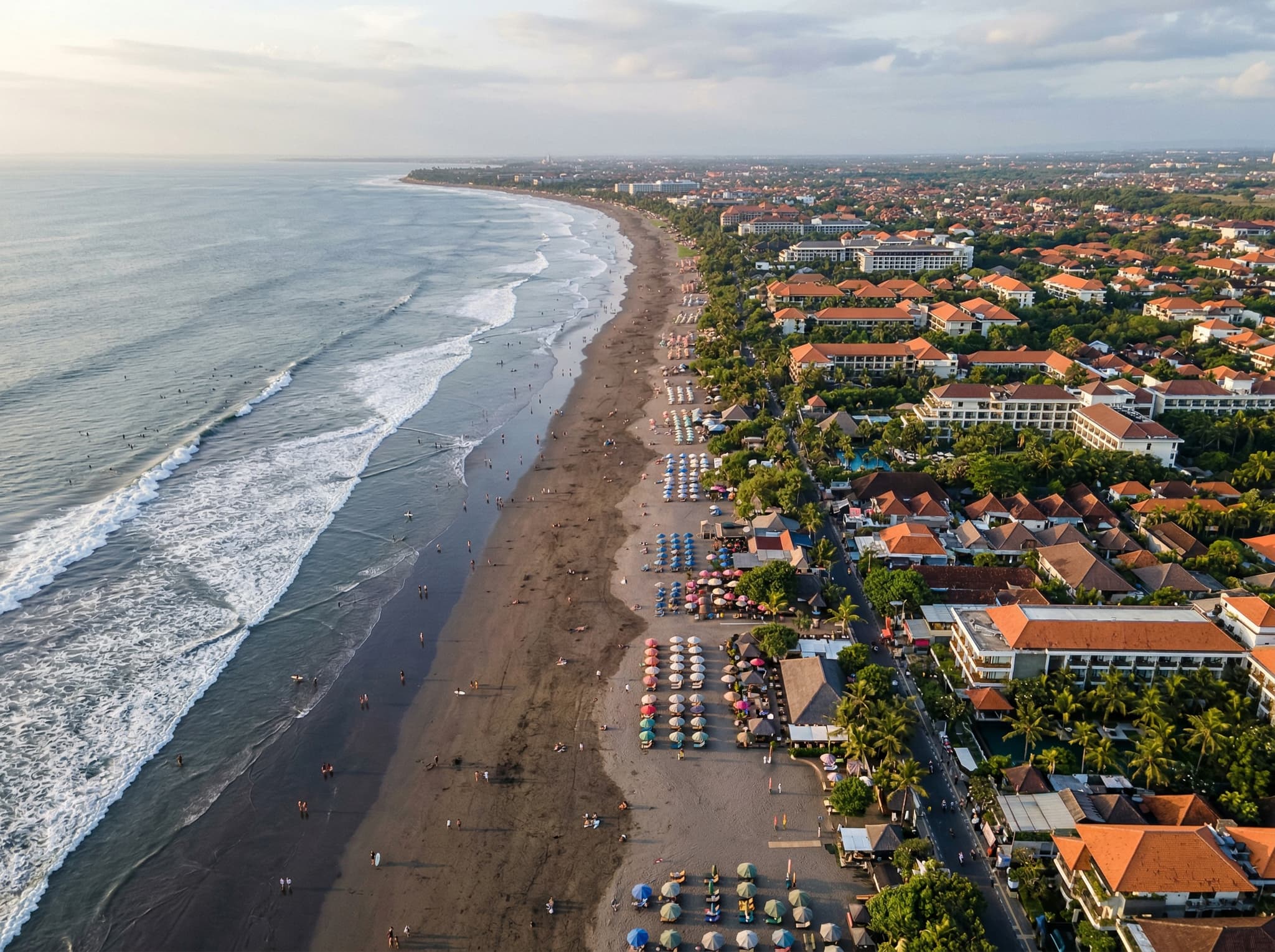 Aerial or wide street-level view showing Legian's position between Kuta and Seminyak along Bali's southwest coast — visually reinforcing the article's central argument about Legian as the practical middle-ground base for south Bali